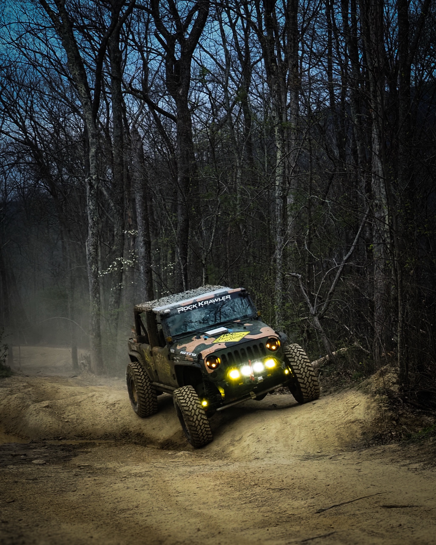 ABO race Jeep ripping through forest trails at night, headlights blazing