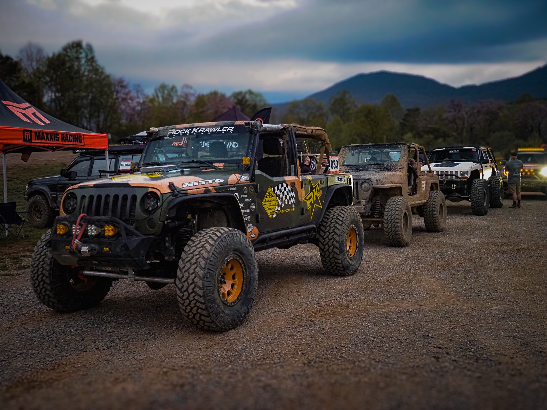 Line of race Jeeps staged at Terra Trophy with the mountains in the background