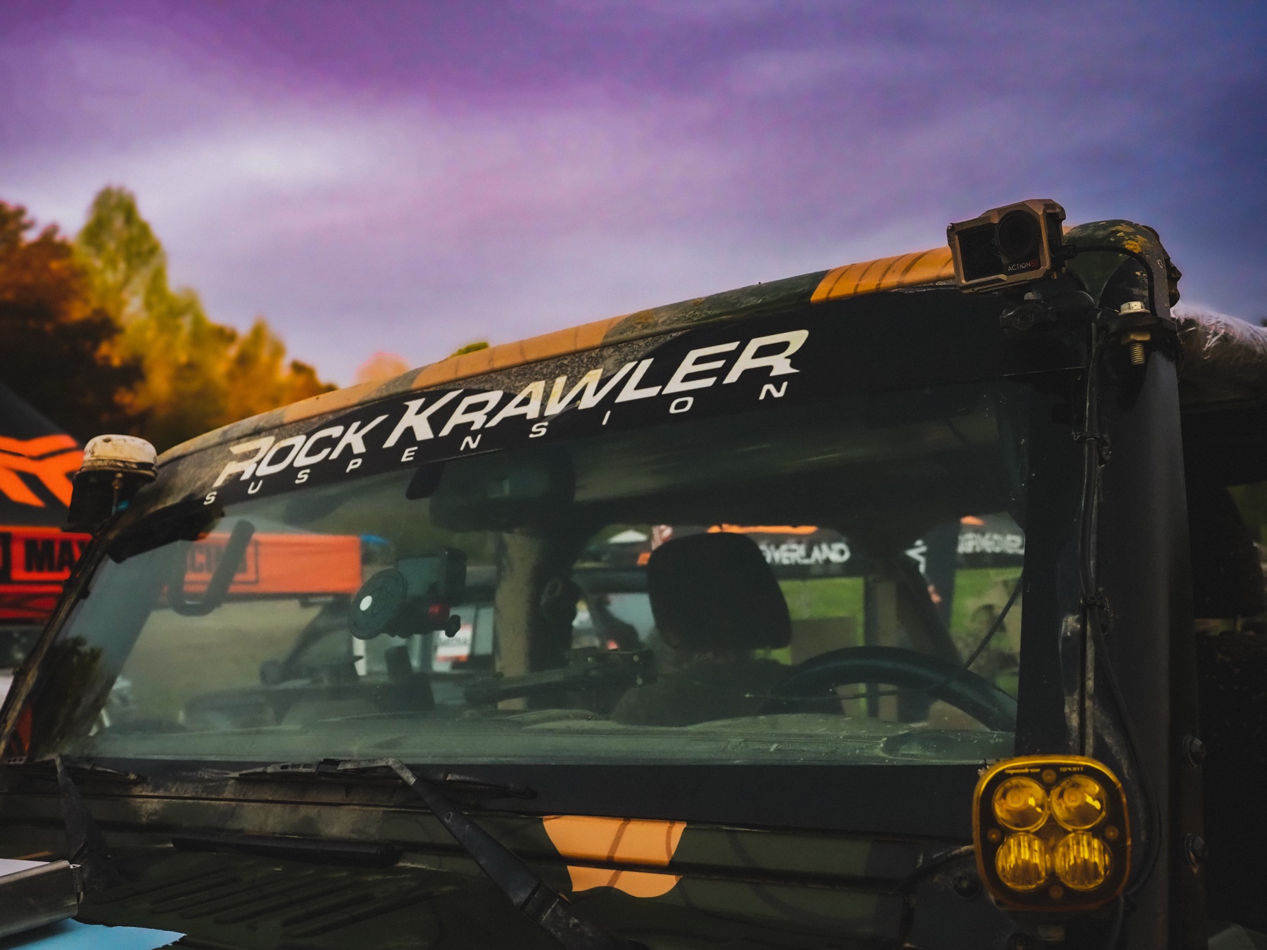Rock Krawler Suspension windshield banner against a purple and orange sky